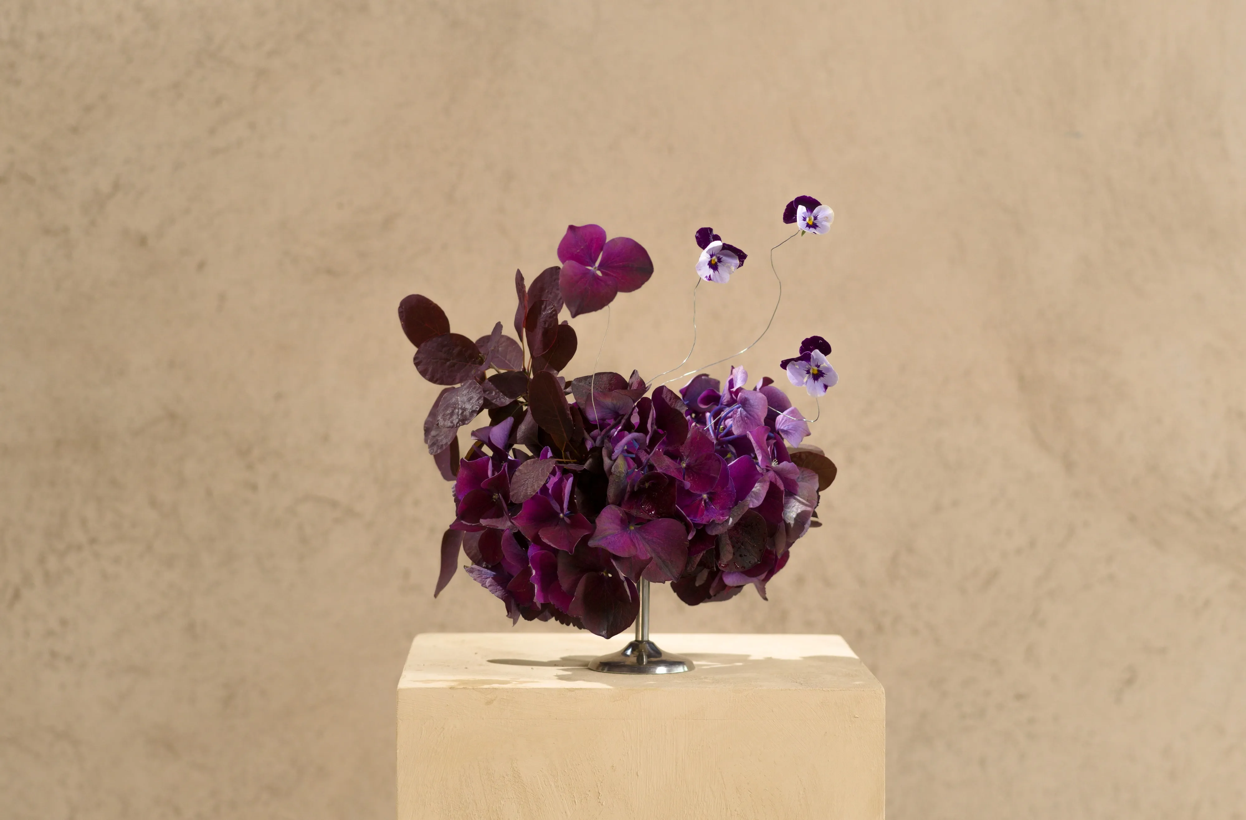 Lila violer och penséer på piedestal